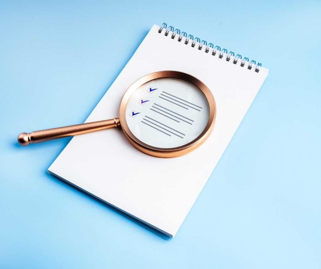 Lupa nad checklistą - symbol audytu i weryfikacji polisy ubezpieczeniowej Lupa nad checklistą - symbol audytu i weryfikacji polisy ubezpieczeniowej
